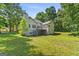 Backyard of home with deck, stairs, mature trees, and green lawn at 40 Wenham Ln, Sharpsburg, GA 30277