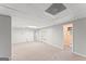 Large, carpeted basement space featuring French doors, neutral paint, and access to a bathroom at 40 Wenham Ln, Sharpsburg, GA 30277