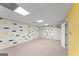 Finished basement space with drop ceiling, brick accent wall and neutral carpet at 40 Wenham Ln, Sharpsburg, GA 30277