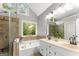 Bright bathroom featuring double vanities, a soaking tub, and a glass-enclosed shower, creating a spa-like retreat at 40 Wenham Ln, Sharpsburg, GA 30277