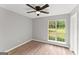 Bright bedroom with wood floors, a ceiling fan, and a large window, perfect for a restful night's sleep at 40 Wenham Ln, Sharpsburg, GA 30277