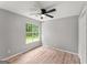 Comfortable bedroom featuring wood floors, a ceiling fan, and a window with a pleasant view at 40 Wenham Ln, Sharpsburg, GA 30277