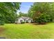Beautifully landscaped home on a lush green lawn surrounded by trees, offering a serene and inviting curb appeal at 40 Wenham Ln, Sharpsburg, GA 30277