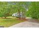 Charming home exterior featuring blue shutters, lush landscaping, and a long driveway, nestled among mature trees at 40 Wenham Ln, Sharpsburg, GA 30277