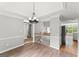 Open concept living area with hardwood floors, wainscotting, and an elegant chandelier at 40 Wenham Ln, Sharpsburg, GA 30277