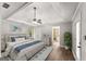 Bright main bedroom with a tray ceiling, ceiling fan, wood floors, and an en-suite bathroom at 40 Wenham Ln, Sharpsburg, GA 30277
