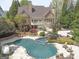 Aerial view of the backyard with a pool, spa, patio, and landscaped gardens surrounding the property at 113 Regents Sq, Peachtree City, GA 30269
