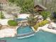 Backyard showcasing a stone pool with waterfall features, a spa, and an outdoor kitchen with covered seating at 113 Regents Sq, Peachtree City, GA 30269