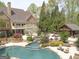 Backyard view showcasing the pool, spa, outdoor lounge area, and lush greenery surrounding the property at 113 Regents Sq, Peachtree City, GA 30269