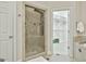 Bathroom with tiled shower and an open doorway to a spacious walk-in closet with custom shelving at 113 Regents Sq, Peachtree City, GA 30269