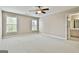 Bright bedroom with neutral walls, carpet, and natural light from two windows, conveniently located near the bathroom at 113 Regents Sq, Peachtree City, GA 30269