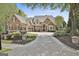 Stately brick home with manicured landscaping, a circular driveway, and a three-car garage at 113 Regents Sq, Peachtree City, GA 30269