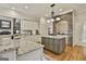 Beautiful kitchen with stone backsplash, granite countertops, stainless steel appliances, and a spacious island at 113 Regents Sq, Peachtree City, GA 30269