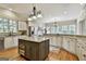 Open kitchen with stone backsplash, granite countertops, stainless steel appliances, and island at 113 Regents Sq, Peachtree City, GA 30269