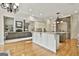 Open-concept kitchen with granite countertops, white cabinets, and decorative chandelier lighting at 113 Regents Sq, Peachtree City, GA 30269