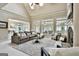 Open-concept living room with large windows, a cozy fireplace, and a stylish seating area at 113 Regents Sq, Peachtree City, GA 30269