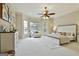 Serene main bedroom with large windows, sitting area, ceiling fan, and plush carpet at 113 Regents Sq, Peachtree City, GA 30269