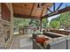 Covered patio with full outdoor kitchen featuring stainless steel appliances, ample seating, and a cozy fireplace at 113 Regents Sq, Peachtree City, GA 30269