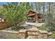 Beautifully landscaped backyard with stone accents and a covered patio area for outdoor dining and entertaining at 113 Regents Sq, Peachtree City, GA 30269
