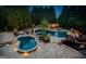 Stunning backyard pool area with hot tub, fire pit, and lounge areas, surrounded by lush landscaping and mature trees at 113 Regents Sq, Peachtree City, GA 30269