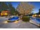 Charming backyard pool with spa, surrounded by lush landscaping, outdoor seating, and a blooming tree at 113 Regents Sq, Peachtree City, GA 30269