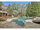 Beautiful freeform pool, water feature, and lush landscaping with outdoor cabana at 113 Regents Sq, Peachtree City, GA 30269