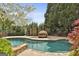 The in-ground pool has lounge chairs, a unique daybed, and lush landscaping at 113 Regents Sq, Peachtree City, GA 30269