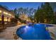 Gorgeous backyard pool featuring a waterfall, surrounded by lush greenery and manicured landscaping, creating a private oasis at 113 Regents Sq, Peachtree City, GA 30269