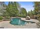 This gorgeous in-ground pool features custom stonework and lush landscaping at 113 Regents Sq, Peachtree City, GA 30269