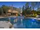 Beautiful backyard pool with waterfall feature and lush landscaping, creating a serene and private oasis at 113 Regents Sq, Peachtree City, GA 30269
