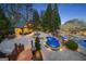 Backyard pool area with an outdoor kitchen, fire pit, and lush landscaping, offering a perfect space for relaxation at 113 Regents Sq, Peachtree City, GA 30269