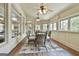 Bright sunroom with wood floors, multiple windows, two ceiling fans and a wicker dining set at 113 Regents Sq, Peachtree City, GA 30269