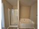 Bathroom featuring a jetted tub and stand up shower with glass door at 1110 Saint Phillips Ct, Locust Grove, GA 30248