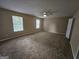 Bedroom with neutral paint, carpeted floors, ceiling fan, and natural light from the window at 1110 Saint Phillips Ct, Locust Grove, GA 30248