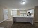 Modern kitchen with an island, white cabinets, and stainless steel appliances, adjacent to the living area at 1110 Saint Phillips Ct, Locust Grove, GA 30248