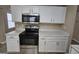 Close-up of kitchen with stainless steel oven, microwave, white cabinets, and stone countertops at 1110 Saint Phillips Ct, Locust Grove, GA 30248