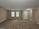 Bright living room with two windows, neutral walls, and new carpeting near front entry at 1110 Saint Phillips Ct, Locust Grove, GA 30248