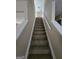 Carpeted staircase featuring white banisters and handrail at 1110 Saint Phillips Ct, Locust Grove, GA 30248