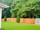 A well-manicured backyard with a charming wooden fence, mature trees, and a storage shed at 789 Winbrook Dr # 1, Mcdonough, GA 30253