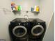 Efficient laundry area with modern black washer and dryer units, plus practical shelving for supplies at 789 Winbrook Dr # 1, Mcdonough, GA 30253