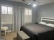 Comfortable bedroom featuring a ceiling fan, chair, and windows dressed with white blinds and decorative curtains at 30 Highlands Ln, Oxford, GA 30054