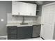 This kitchenette features white cabinets, stainless steel appliances, and a gray backsplash at 30 Highlands Ln, Oxford, GA 30054