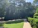 Well-manicured yard and walkway with mature trees, showcasing the property's curb appeal at 30 Highlands Ln, Oxford, GA 30054