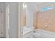 Well-lit bathroom has a shower-tub combo with decorative tile, complemented by a white sink and vanity at 1500 Royce Dr, Locust Grove, GA 30248