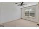 Bedroom features a ceiling fan, neutral carpet, and natural lighting at 1500 Royce Dr, Locust Grove, GA 30248