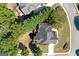 Aerial view of a house featuring a dark grey roof, mature trees, green grass, and a white driveway at 1500 Royce Dr, Locust Grove, GA 30248