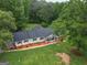 Aerial view of home with a charming front porch, surrounded by lush greenery and a well-maintained lawn at 3290 Ebenezer Se Rd, Conyers, GA 30094