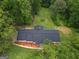 Aerial view of a house with a dark roof and landscaped yard surrounded by lush green trees at 3290 Ebenezer Se Rd, Conyers, GA 30094