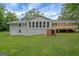 Back exterior view of home with sunroom and attached deck at 3290 Ebenezer Se Rd, Conyers, GA 30094