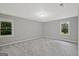 Bright bedroom with two windows, neutral gray walls, plush gray carpet, and natural light at 3290 Ebenezer Se Rd, Conyers, GA 30094